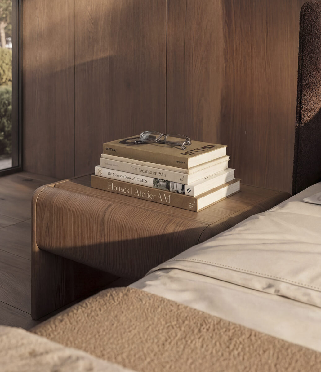 Modern wooden bedside table with stacked books and glasses in a cozy bedroom setting.