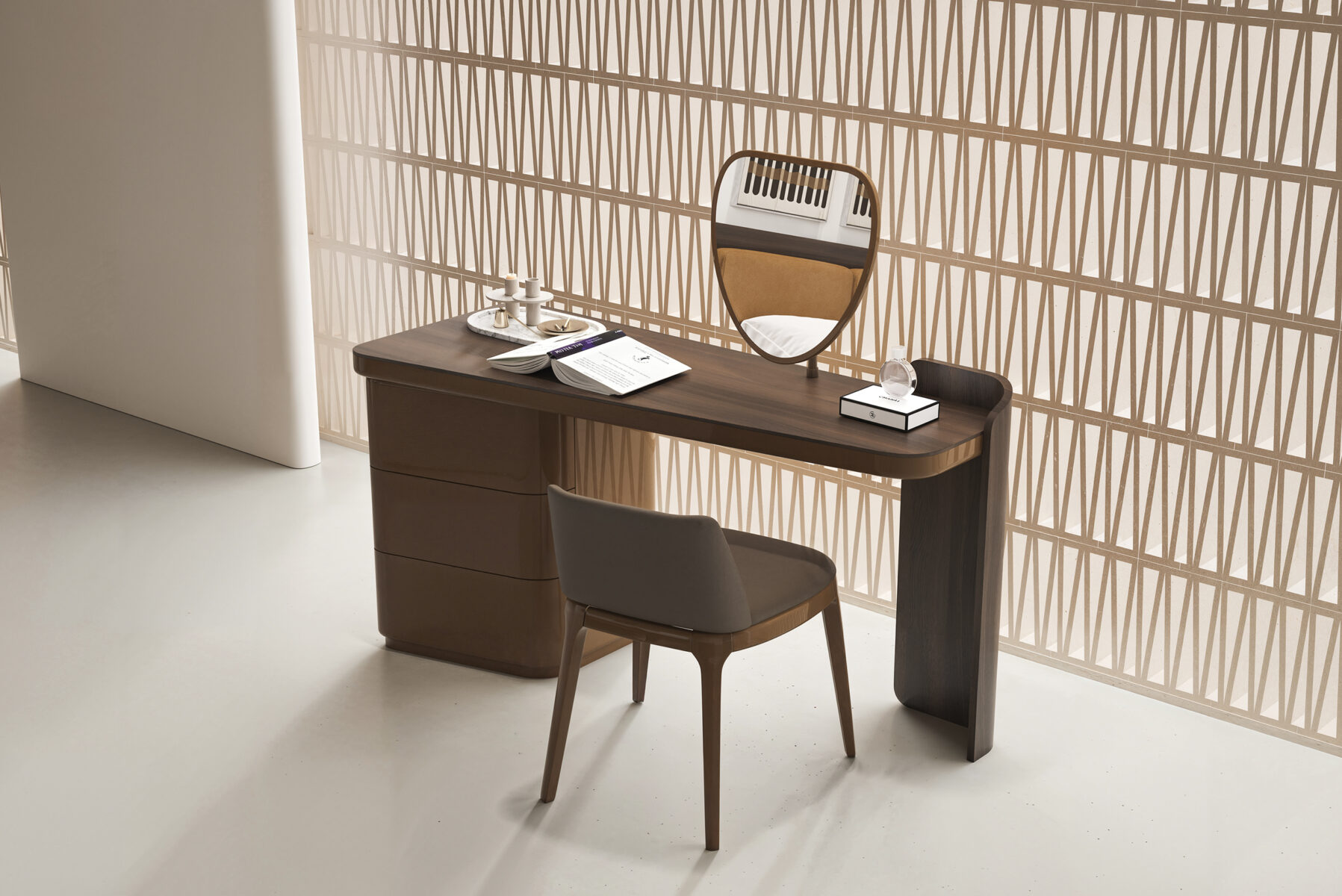 An elegant modern desk with a mirror, chair, and accessories in a stylish interior setting.