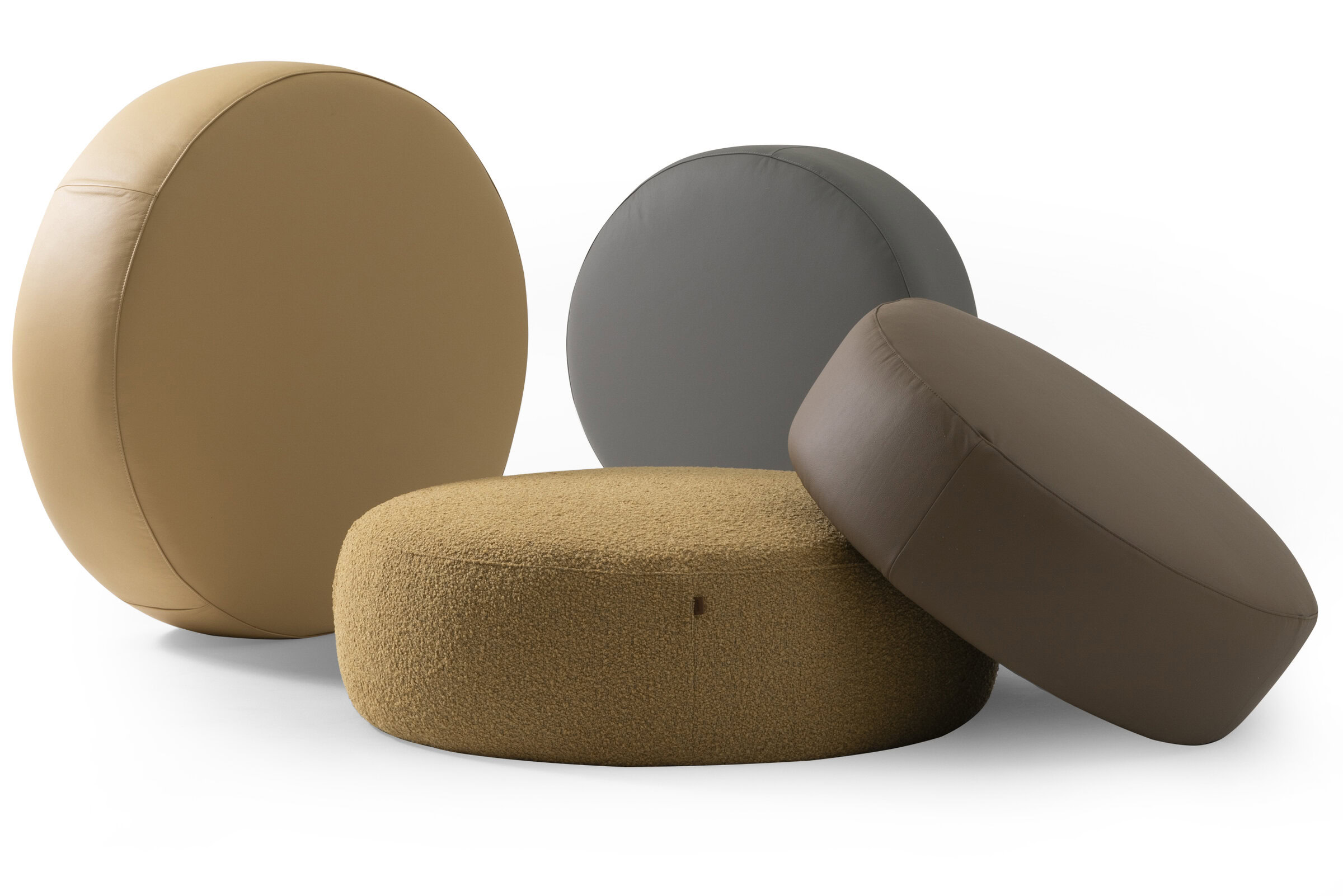 Round contemporary poufs and ottomans in neutral tones, perfect for modern living room decor and versatile interior design. Comfortable and stylish furniture pieces.