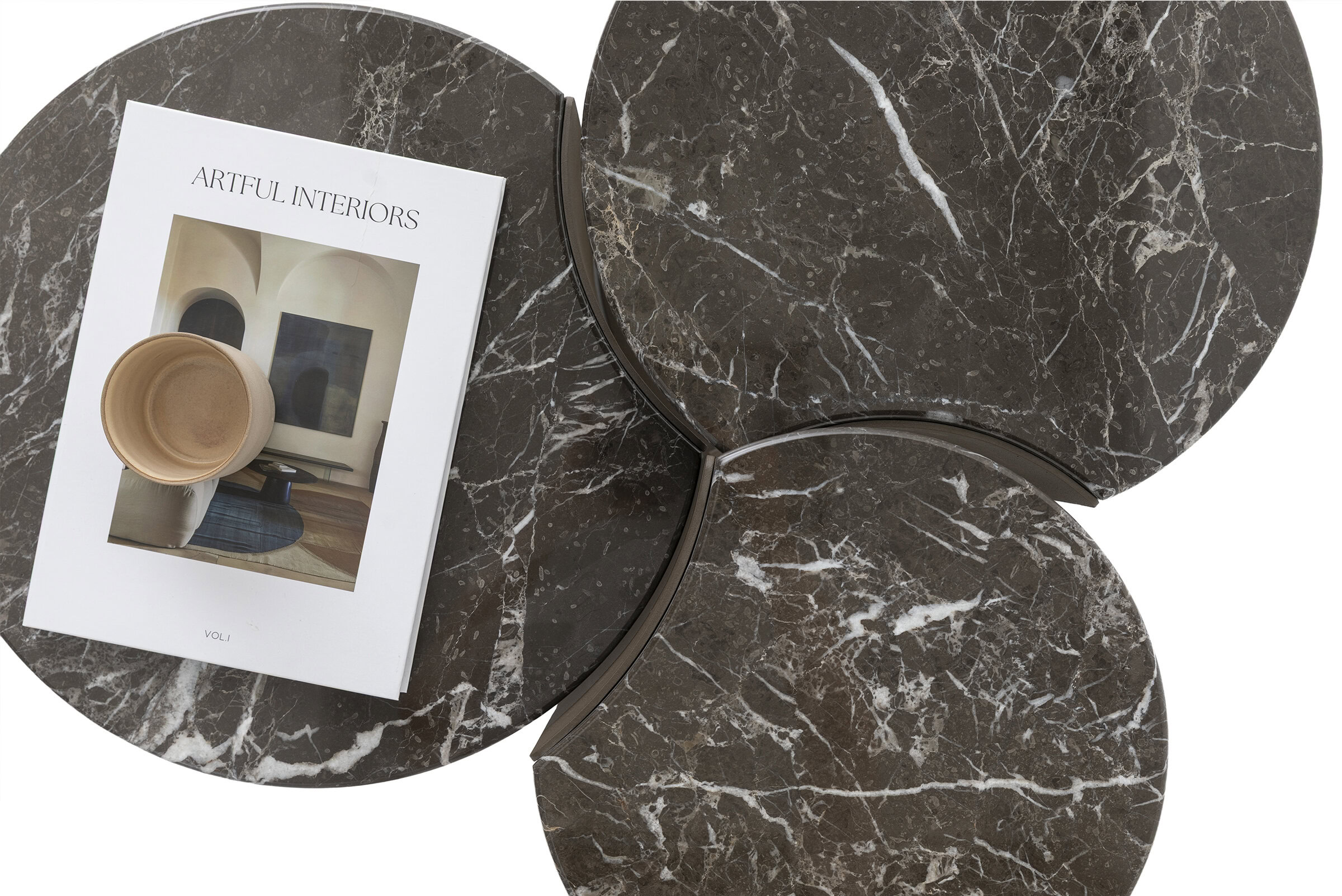 Set of three round marble coffee tables with dark brown and white veining, arranged with a magazine and a small bowl on one of the tables.