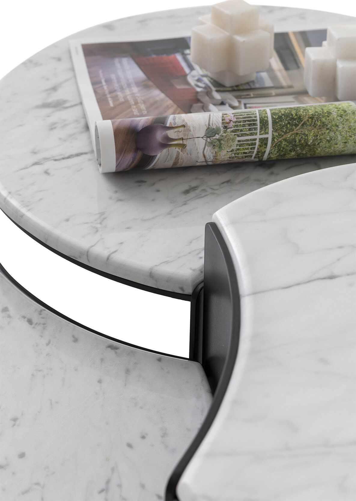 Elegant white marble coffee table with black trim, featuring a magazine and candles on top, showcasing modern design and high-quality craftsmanship.
