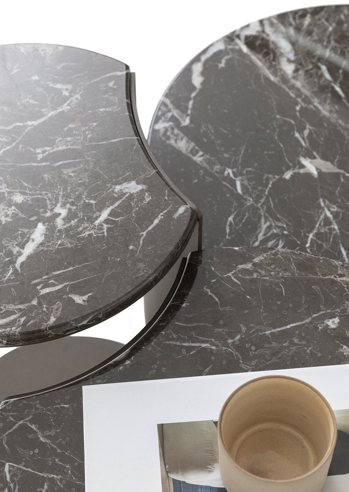 Elegant marble coffee tables with a dark gray and white veined finish, showcasing modern design and craftsmanship from Saloni Furniture.