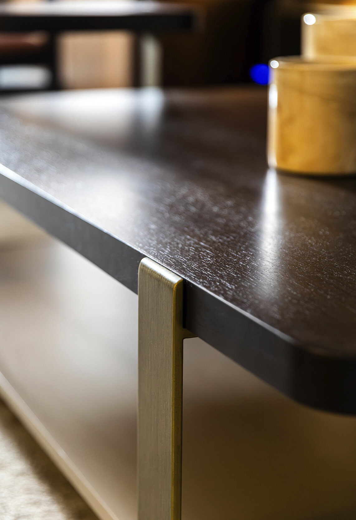 Close-up of a sleek, dark wood coffee table with gold accents from Saloni Furniture, showcasing contemporary design and high-quality craftsmanship.
