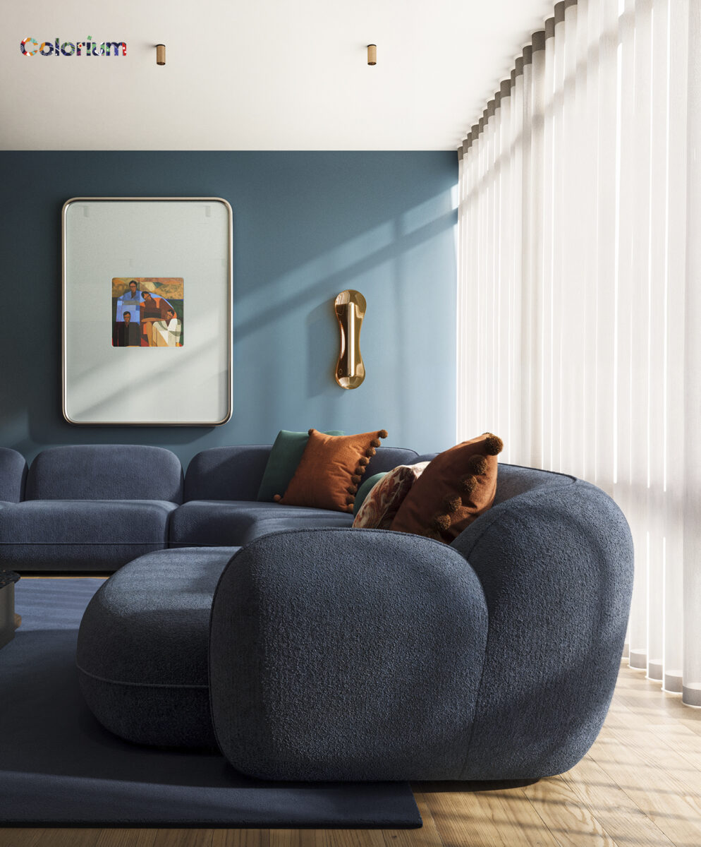 Contemporary blue sofa set with orange and green cushions in a stylish living room by Saloni Furniture, featuring a blue accent wall and modern decor.