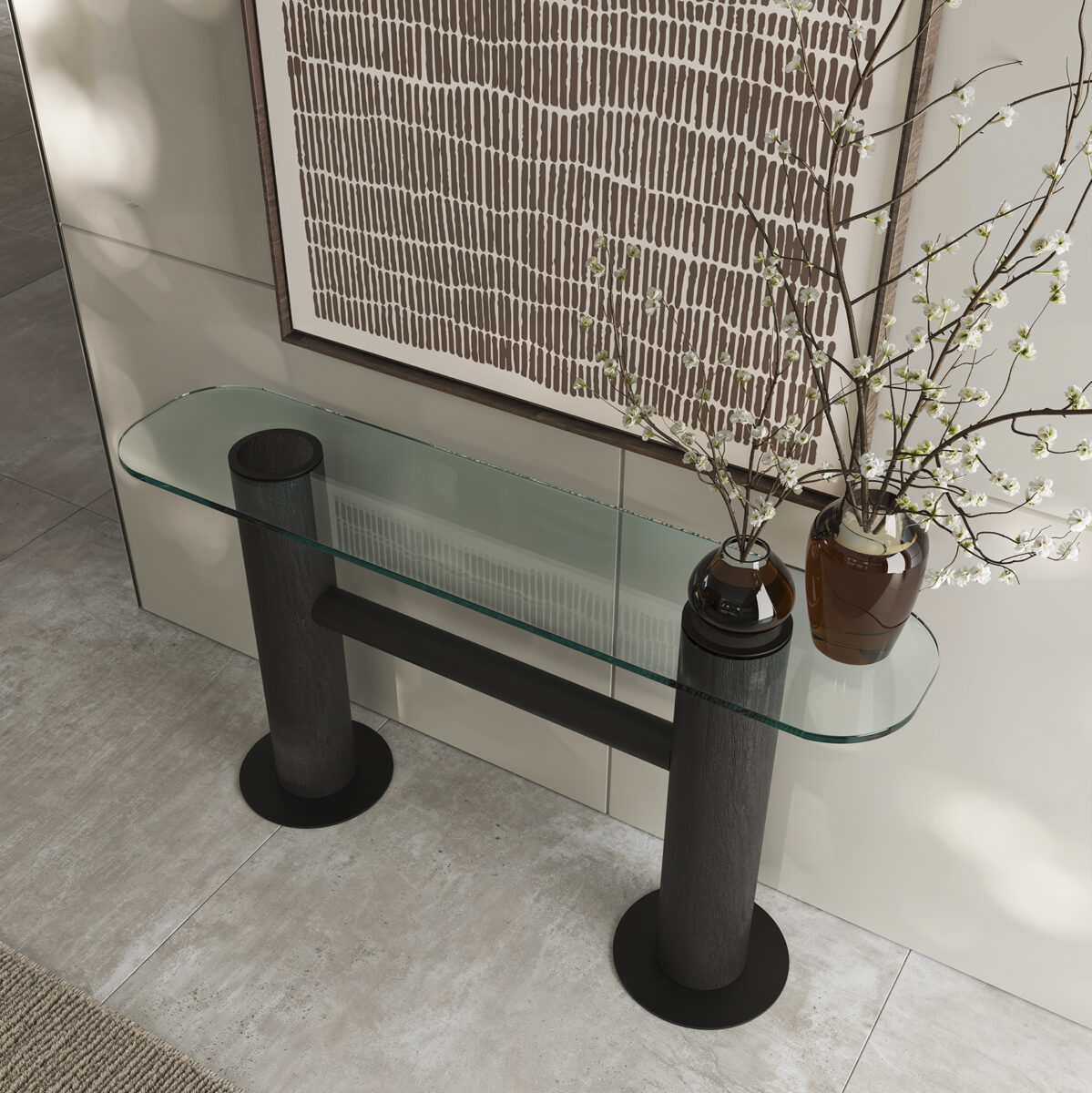 Elegant glass console table with black cylindrical legs, decorated with two brown vases filled with flowering branches, in a contemporary interior setting.