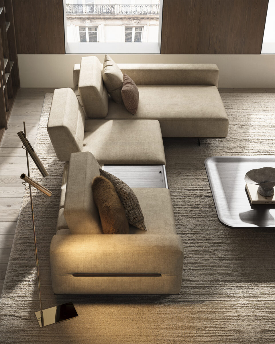 Elegant beige sectional sofa with decorative pillows in a contemporary living room setting, featuring a wooden floor and large window.