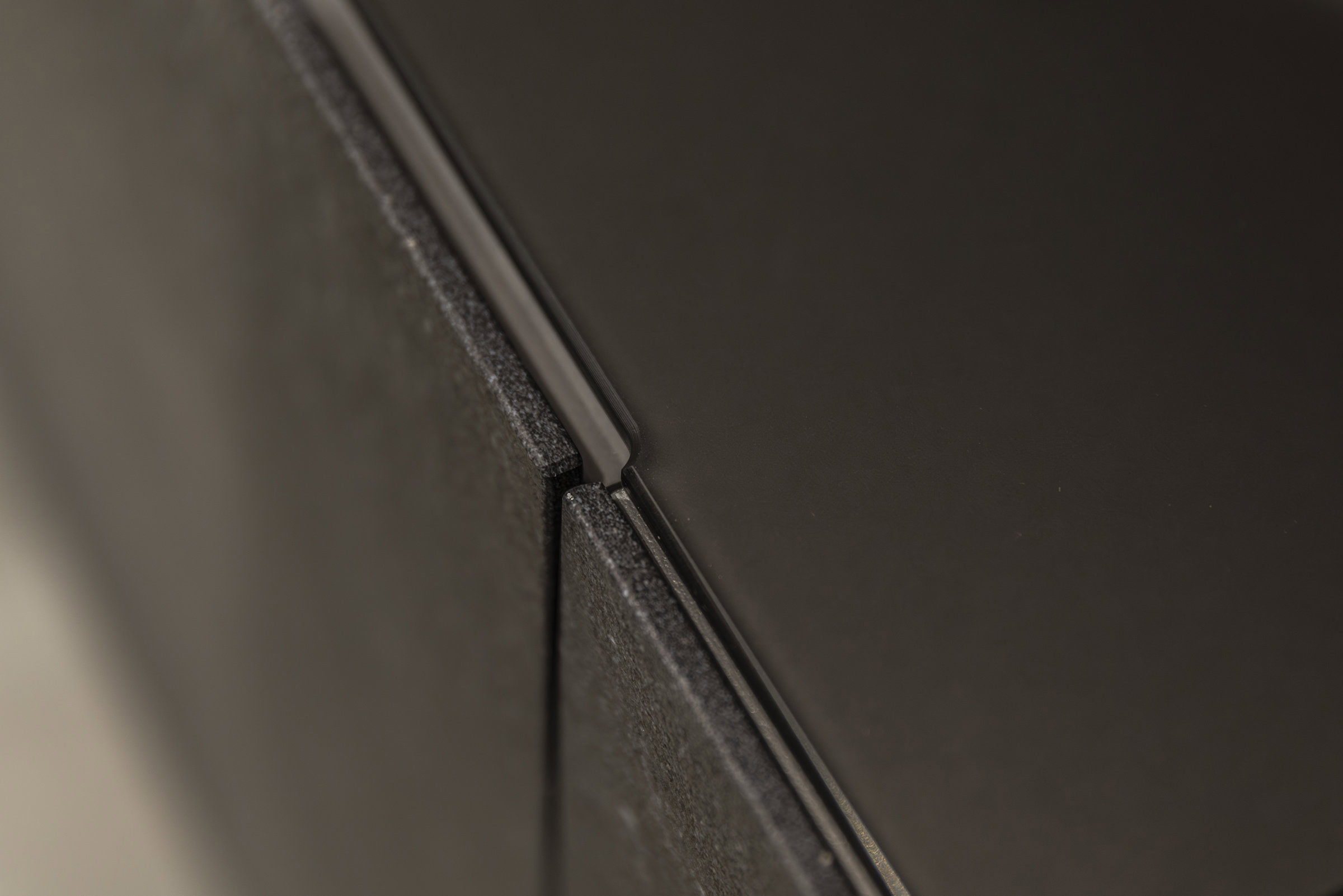 Sleek close-up of modern black furniture corner emphasizing smooth surfaces and precise craftsmanship, highlighting high-quality materials and stylish design for contemporary interior decor.