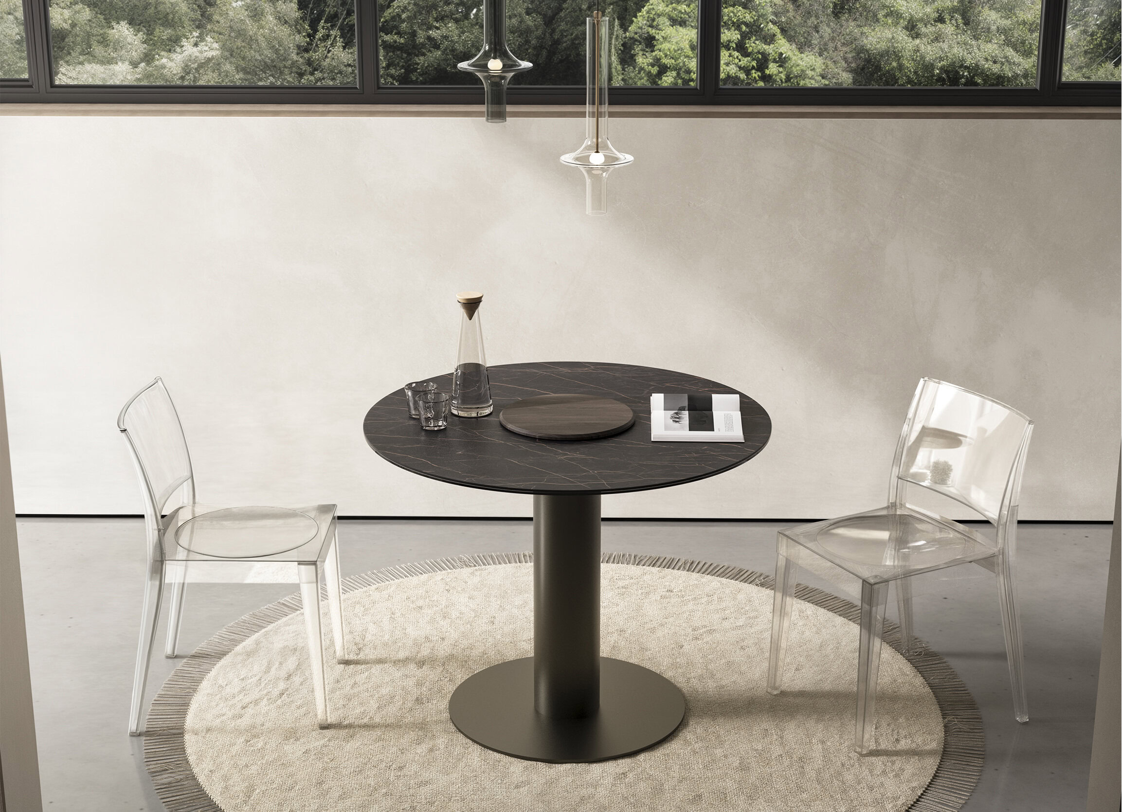 Sleek black marble round dining table with a modern pedestal base, paired with transparent acrylic chairs in a stylish, minimalistic dining space. Perfect for contemporary home interior design.