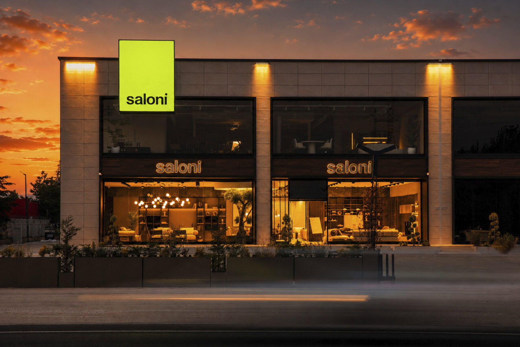 Exterior view of Saloni Furniture store during sunset, showcasing modern architecture and illuminated signage.